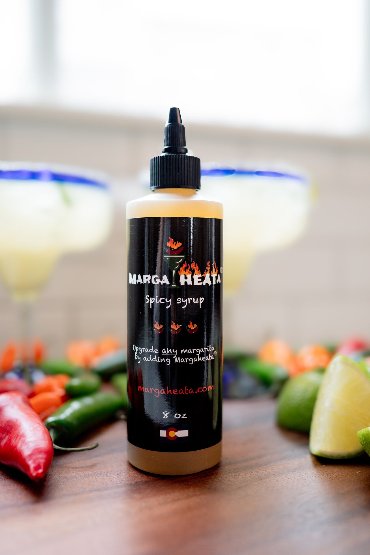 Margaheata® Swicy Syrup bottle with fresh peppers